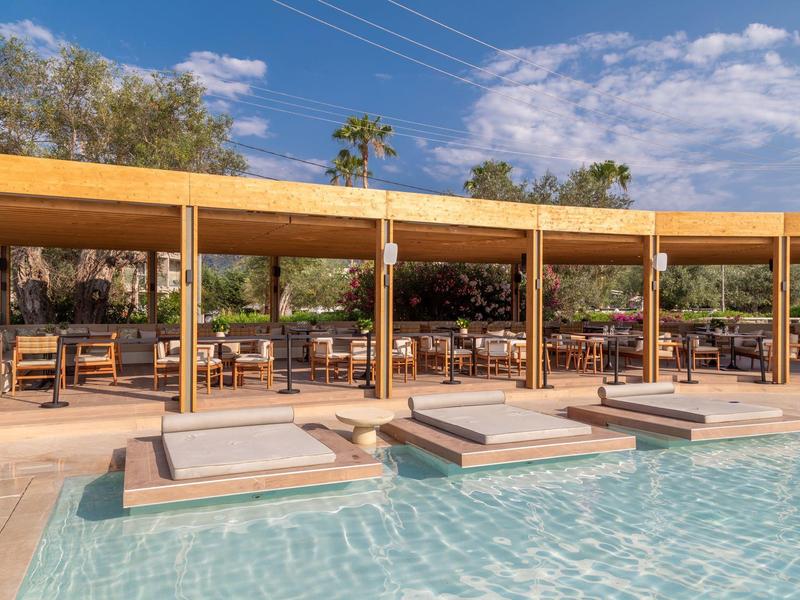 Moderner Poolbereich mit eingebauten Sonnenliegen und Holzüberdachung