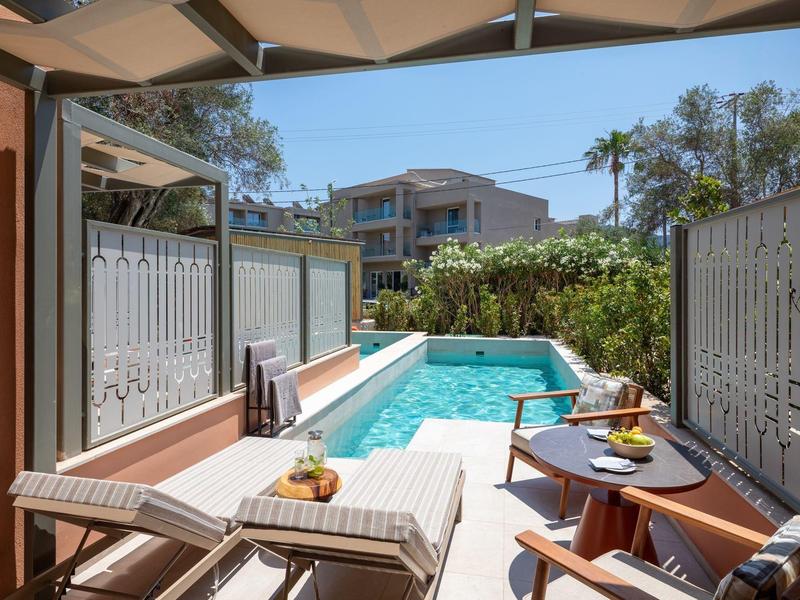Terrasse mit Pool, Liegestühlen und Tisch mit Getränken in einem Hotel