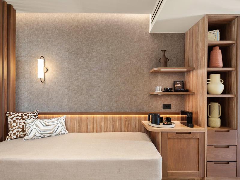 Modern eingerichteter Raum mit Bett, Holzregalen und stilvoller Beleuchtung