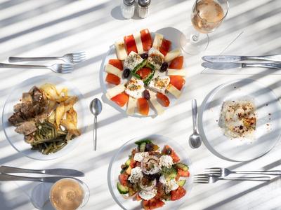 Une table dressée avec divers plats et boissons au soleil.