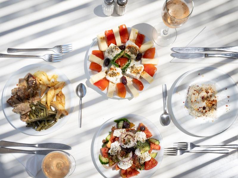 Une table dressée avec divers plats et boissons au soleil.