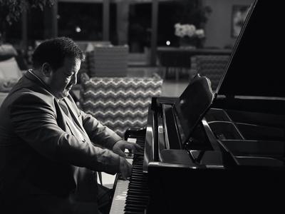 Mężczyzna gra na pianinie z koncentracją w elegancko urządzonym pokoju.