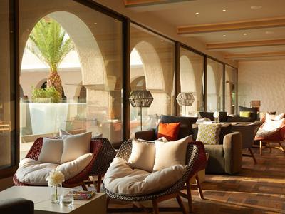 Gemütlicher Innenraum mit großen Bögen, Holzfußboden und bequemen Sesseln mit Kissen.