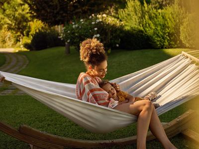 Una mujer se relaja en una hamaca en el jardín bajo la luz del sol.