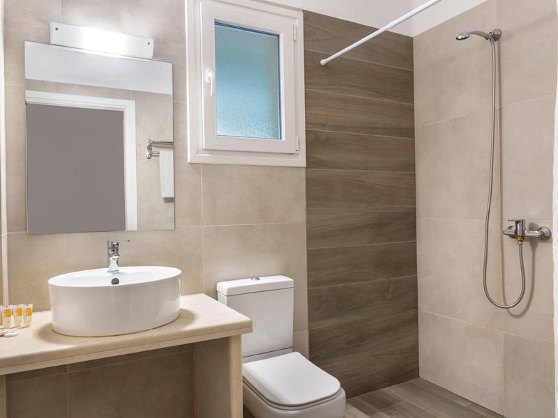 Modernes Badezimmer mit Waschbecken, Spiegel, Toilette und begehbarer Dusche in neutralen Tönen.