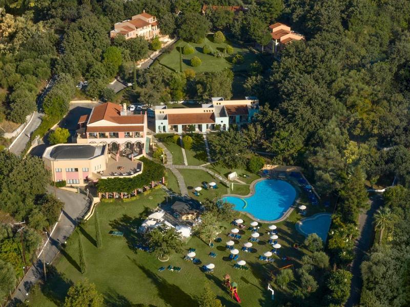 Großes Anwesen mit mehreren Gebäuden, Pool, Sonnenschirmen und viel Grünfläche, umgeben von dichtem Wald.