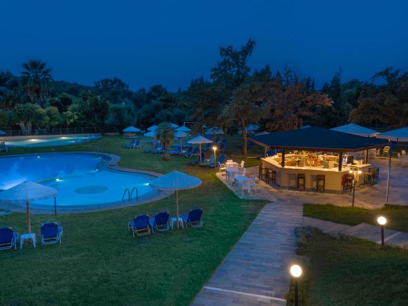 Beleuchteter Poolbereich mit Liegestühlen und überdachtem Sitzbereich in der Dämmerung.