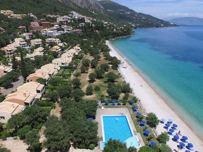 Küste mit Hotelanlage, Pool und Sandstrand neben klarem blauem Meer.