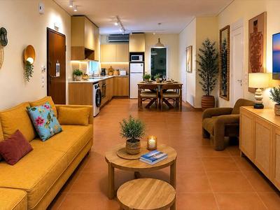 Bright living room with yellow sofa, wooden furniture, and open kitchen in a vacation apartment.