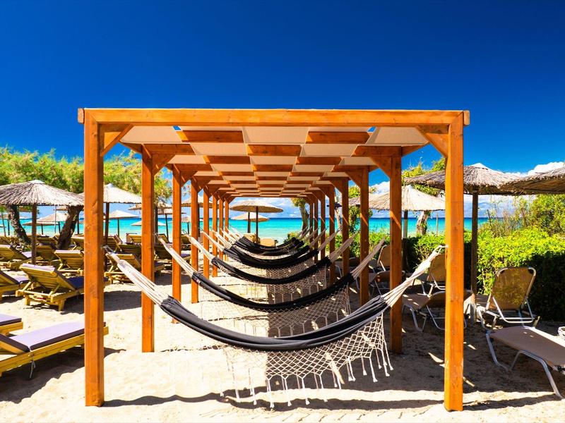 Hängematten unter einem Holzpavillon am Strand mit Blick auf das Meer.