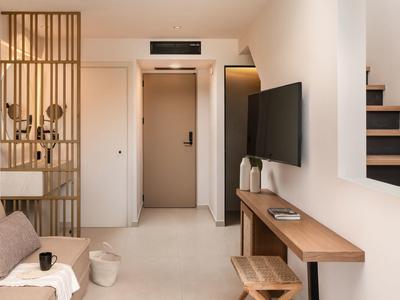 Helles modernes Zimmer mit Holzmöbeln, TV, Sitzbank und Treppe auf der rechten Seite.