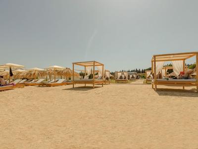Spiaggia sabbiosa con ombrelloni e lettini sotto un cielo limpido