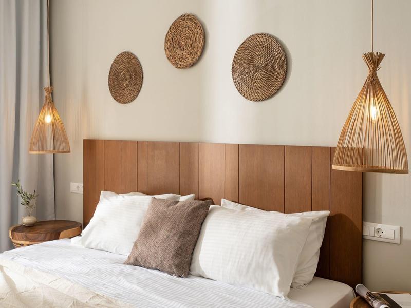 Modernes Schlafzimmer mit braunem Polsterbett, weißen Kissen und drei runden Wanddekorationen.