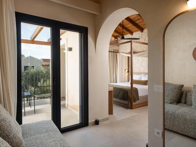 Modern eingerichtetes Hotelzimmer mit Zugang zur Terrasse und gemütlichem Sitzbereich.