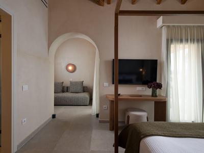 Ein gemütliches Hotelzimmer mit einem Bett, einem Fernseher und einem angrenzenden Sitzbereich.