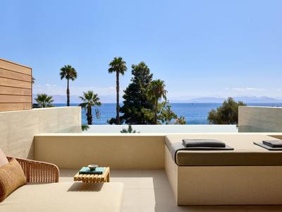Moderne Terrasse mit bequemen Sitzgelegenheiten und Blick auf das Meer und die Berge.