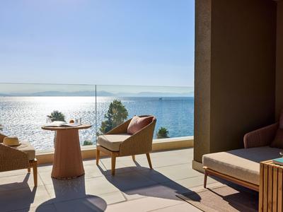 Terrasse mit Sitzmöbeln und Meerblick bei klarem Himmel