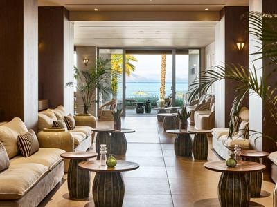 Modern eingerichteter Hotel-Loungebereich mit bequemen Sofas und Blick auf das Meer.