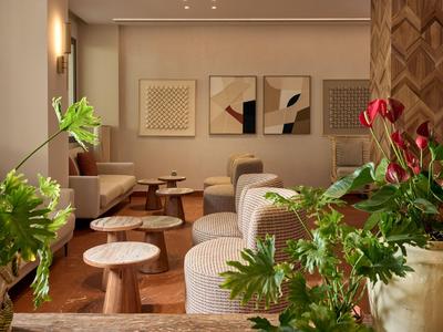 Modern eingerichteter Hotel-Warteraum mit bequemen Sesseln und grünen Pflanzen.