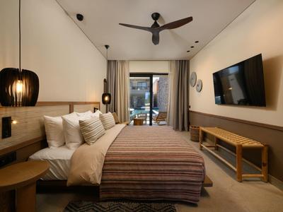 Modernes Schlafzimmer mit großem Bett, deckenhohen Vorhängen, Deckenventilator und Wand-TV.