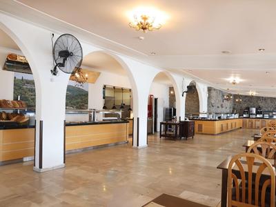 Ruime eetzaal met buffet en houten tafels in een hotel.