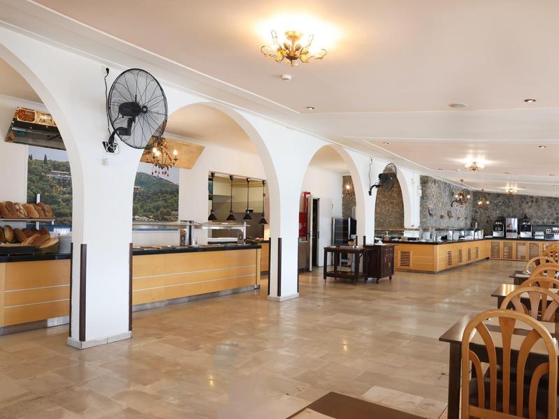 Ruime eetzaal met buffet en houten tafels in een hotel.