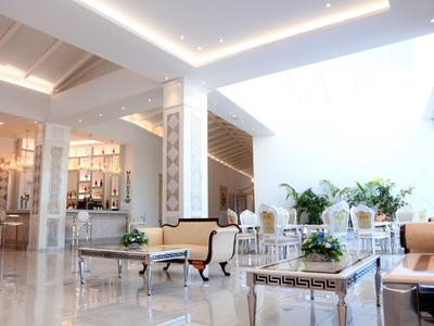 Hall di hotel moderno e luminoso con divani, tavoli e molta luce naturale.