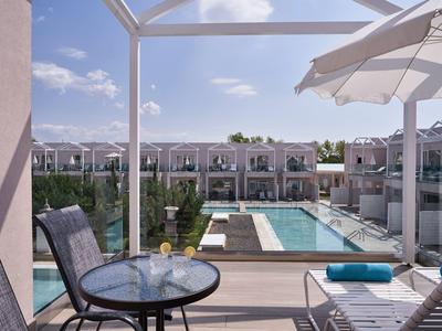 Vista su una piscina con lettini e tavoli sul balcone di un hotel.