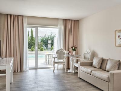 Soggiorno moderno e luminoso con divano, tavolo e vista su terrazza e giardino.