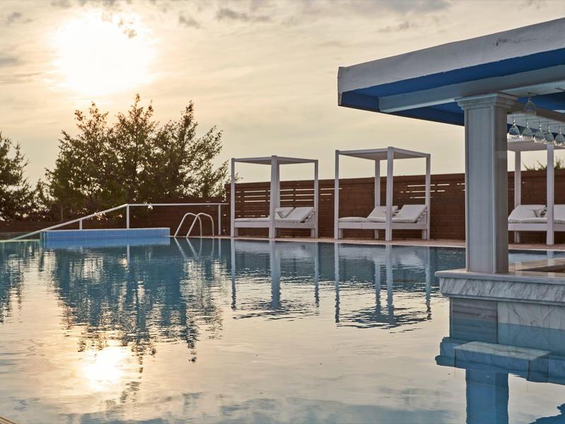 Area relax con piscina, lettini e ombra al tramonto