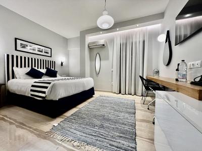 Modern eingerichtetes Hotelzimmer mit großem Bett, Schreibtisch und Teppichboden.
