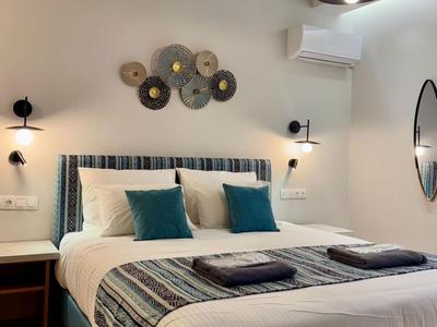 Modern eingerichtetes Hotelzimmer mit großem Bett, Wanddeko und indirekter Beleuchtung.