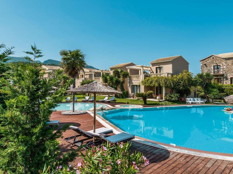 Aantrekkelijk zwembadgebied met ligstoelen en stroparasols voor mediterrane hotelgebouwen.