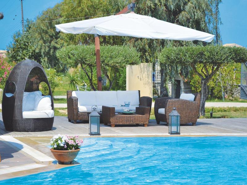 Zwembadgedeelte met moderne buitenlounge, parasol en bloeiende planten.