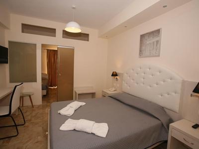 Przytulny pokój hotelowy z łóżkiem podwójnym, dwoma ręcznikami i nowoczesnym wystrojem.