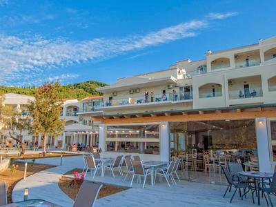 Chambre d'hôtel lumineuse avec lit, bureau, chaise et fenêtre avec rideaux.