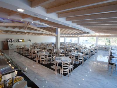 Taras z stołami i parasolami przed hotelem na wzgórzach.