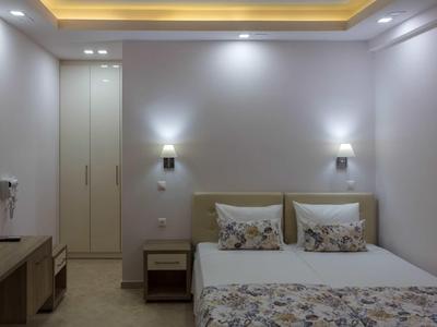 Chambre d'hôtel moderne avec lit double, table de chevet et éclairage de plafond indirect.