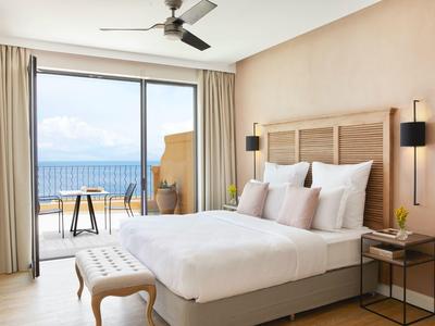 Nowoczesny pokój hotelowy z łóżkiem podwójnym, tarasem i widokiem na morze za dnia