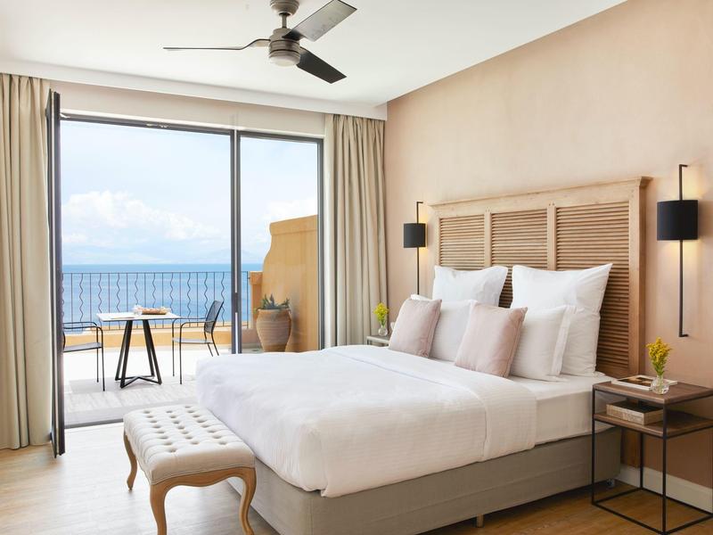 Nowoczesny pokój hotelowy z łóżkiem podwójnym, tarasem i widokiem na morze za dnia