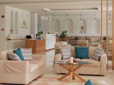 Helles, modernes Wohnzimmer mit beigen Sofas, gemusterten Kissen und einem Holztisch.