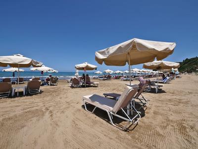 Spiaggia con lettini e ombrelloni sotto un cielo azzurro limpido in una località turistica.