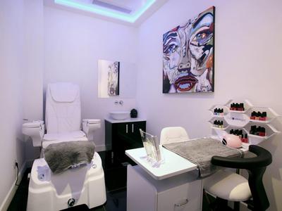 Moderne Nagelstudio-Ecke mit Pediküre-Stuhl und Nagelpflege-Tisch in Weiß und Schwarz.