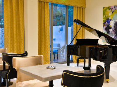 Moderní místnost s černými křídly, smetanovým sezením a žlutými závěsy u oken.