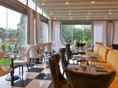 Světle restaurace s moderním interiérem a velkými okny s výhledem do zahrady.