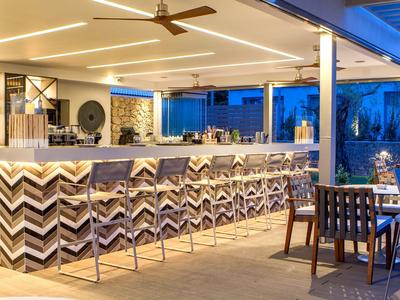 Moderní venkovní bar s elegantním osvětlením a posezením večer.