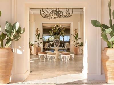 Heller Hotel-Lobbybereich mit Pflanzen in großen Töpfen und stilvoller Dekoration.