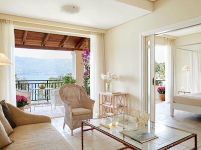 Helles Wohnzimmer mit Balkon und Blick auf das Meer in einem Hotelzimmer.