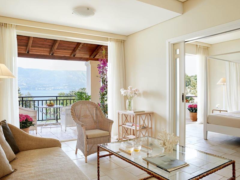 Helles Wohnzimmer mit Balkon und Blick auf das Meer in einem Hotelzimmer.