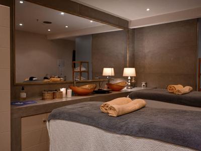 Gemütlicher Spa-Raum mit Massageliegen, Handtüchern und sanfter Beleuchtung.